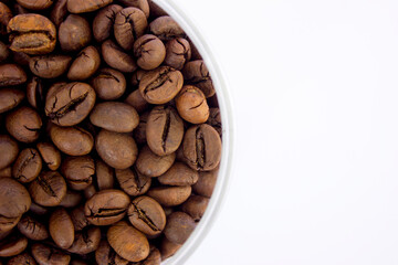 Roasted Robusta coffee beans inside a container isolated on a white background.