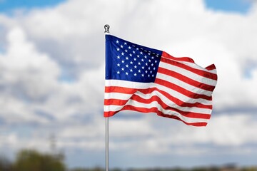 Fototapeta premium American Flag Blowing in Wind with Sky Background