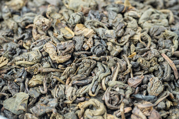 close-up of curled green tea leaves. food background. Tea drinking tradition of China and India. Macro photo, top view, flat lay