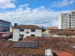 Roofs of the city of Santos, with one featuring a solar panel.

