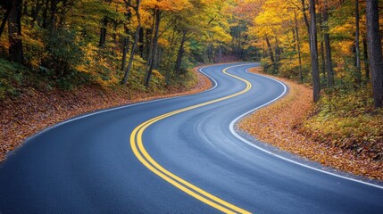 Fototapeta premium A scenic highway winds through a colorful autumn forest. Beautiful fall foliage lines the mountain road.