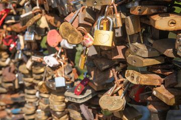 abstract wallpaper with many metal love locks on the bridge shining in sun light