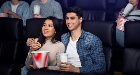 On movie date. Happy smiling boyfriend and girlfriend in cinema