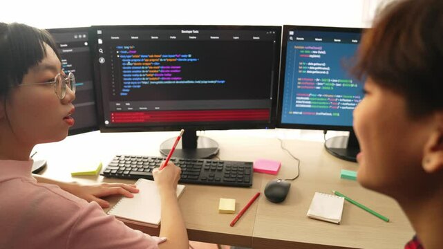 Slow motion back end software developer engineer for computer programming working together on debugging writing computing code, solving complex algorithms display on monitor in office. Burgeoning