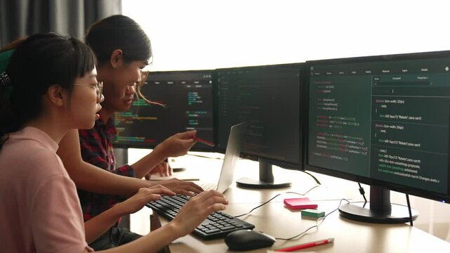 Back end software developer engineer for computer programming working together on debugging writing computing code, solving complex algorithms display on monitor in office. Burgeoning