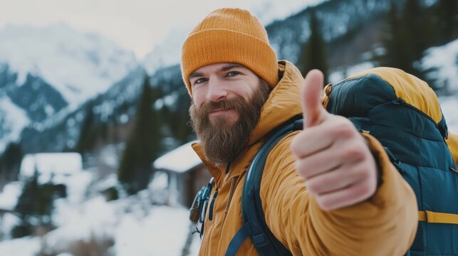 Man gives thumbs up during winter hike in snowy mountains