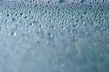 Krople wody. Jasne niebieskie tło. Tekstura kropli wody na płaskiej powierzchni i bokeh