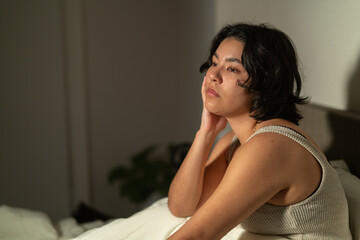 Naklejka premium Young woman suffering from insomnia sitting on bed at night