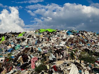 Garbage dump on a cloudy sky background. Waste products of human life