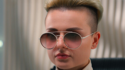 Fototapeta premium Caucasian fashion girl futuristic woman in eyeglasses white studio modern future innovation close-up cyber female model lady cyberpunk trendy eyewear stylish glasses relax on chair close eyes meditate