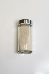 A glass jar containing onion salt, a perfect seasoning for dishes.