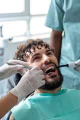 Man patient during visit to the clinic for routine cavity checkup sitting in treatment chair