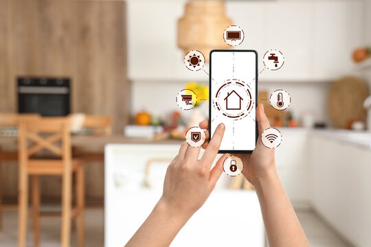 Blurred view of light kitchen with autumn flowers and pumpkins on table
