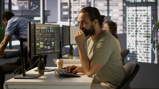 Developer working with artificial intelligence machine learning tech, improving company systems. IT expert in office focused on transforming data into predictive models, camera A