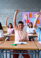 Vertical. Portrait of happy group diverse elementary school students sitting in classroom with...