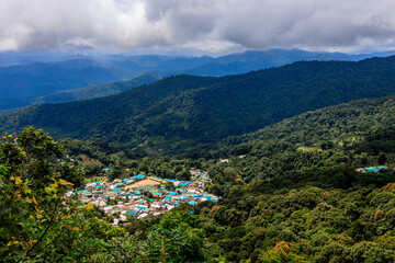 Background of a natural travel landscape with fog covering the road, clear sky from the viewpoint, various trees and cool breeze.