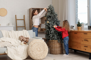 Cute sisters decorating Christmas tree at home