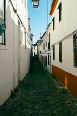 Obraz premium Narrow cobblestone roads and buildings were built close to fend off the hot sun in historical Portugal towns.