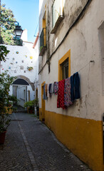 Fototapeta premium Narrow cobblestone roads and buildings were built close to fend off the hot sun in historical Portugal towns.