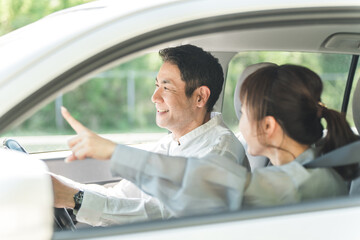 ドライブ中に楽しそうに会話する中年夫婦
