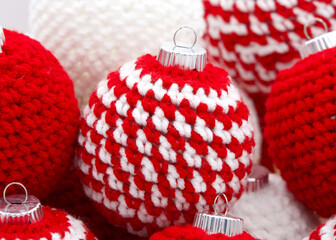 Close up on hand crochet Christmas ornaments in red and white.