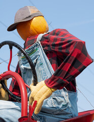 pumpkin head farmer on a tractor with pumpkins