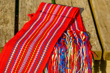 ceinture fléchée (traditional pattern) replica of the woven sash worn by voyageurs during the fur trade on wooden picnic table