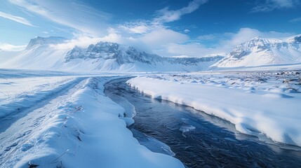 Obraz premium Snowy landscape with mountains and a winding river.