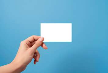 Obraz premium Hand holding a business card with blue background, empty mockup.