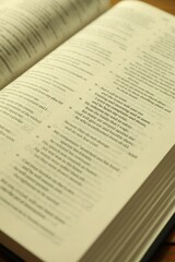 Fototapeta premium Open Holy Bible in English language on wooden table, closeup