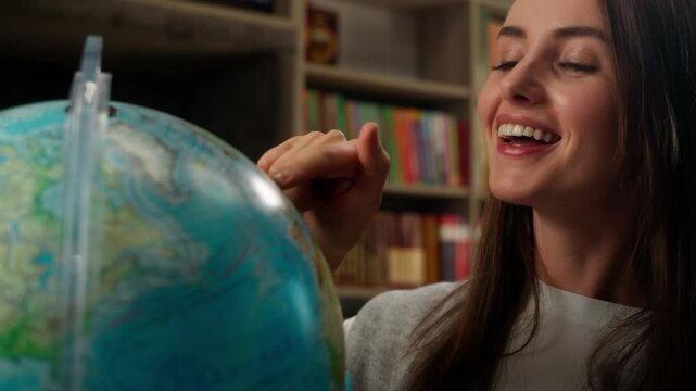 Caucasian woman spinning globe dream choosing country travel traveler wish smile female student girl teacher geography global map world choose study learner pointing finger library school university
