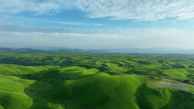 道路、空撮、風景、景色、牧場、高原、草原、青空、環境、自然、絶景、ドローン、地平線、パノラマ、観光、旅行、トレイル、ダイナミック、壮大、広大、新緑、大地、グリーン、エコロジー、エコシステム、地球環境、環境保護、気候変動、サステナブル、SDGs、持続可能な開発目標、サステナビリティ、俯瞰、ハイアングル、展望、鳥瞰図、上から見た、見下ろす、景観、迫力、遠近感、自動車、高地、地球、日本、世界、ファンタジ