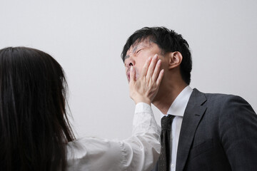 顔を叩かれるビジネスマン