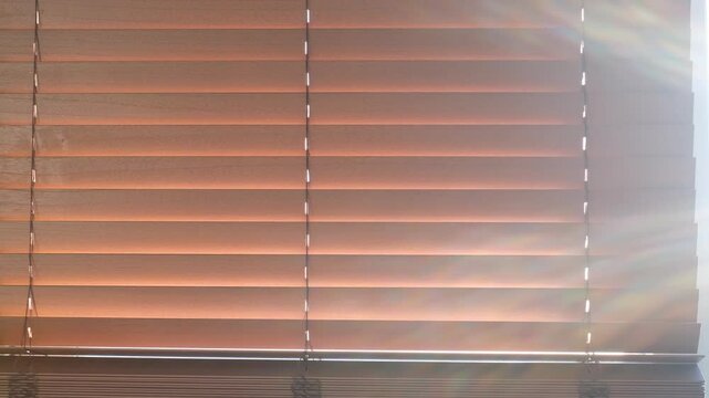 Window with brown wooden blinds close-up front view.