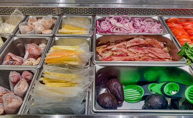 Meats, cheeses and other sandwich or wrap ingredients at a deli counter.