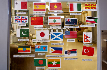 a diverse collection of international flag decals or stickers with a greeting in the corresponding...