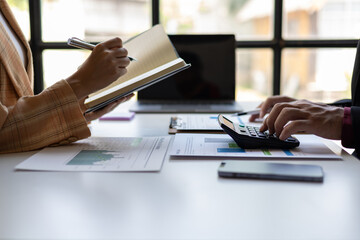 Fototapeta premium Meeting with a financial advisor and auditor are analyzing the financial figures in the business report. Investors are discussing cost analysis and reducing costs to increase profitability.