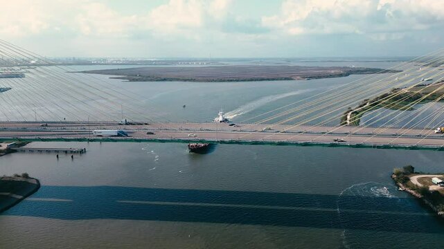 Cargo ship travelling under a high car bridge