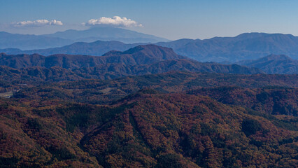 冠雪の北アルプスと紅葉の山並み 