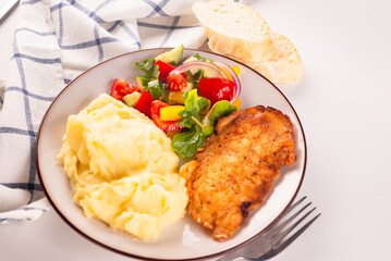 Fried chicken steak or schnitzel with mashed potatoes and vegetables salad in plate