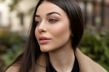 Fototapeta premium Profile view of a young woman with Botox-plumped lips and soft makeup