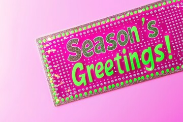 "Season's Greetings!" text with a magenta and neon green border featuring platinum dots, set on a pale lilac background for a vibrant holiday theme