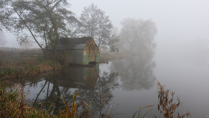 A landscape showing an old corrugated tin coat shed by the side of a pool. Taken in early morning...