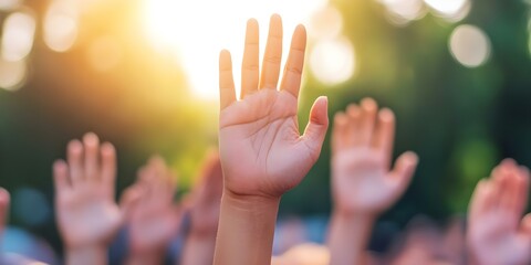 A close-up of raised hands against a bright, blurred background, likely during an outdoor gathering or event. Concept Close-Up Hands, Outdoor Gathering, Bright Background, Event Atmosphere