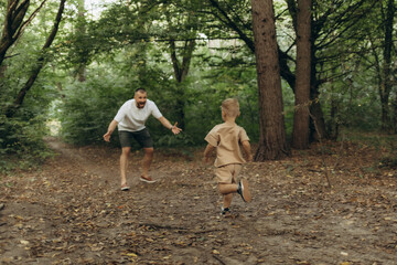 Fototapeta premium Father walking with his little son in park