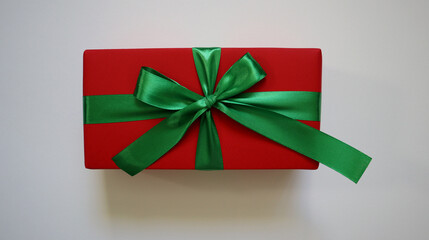 Gift isolated on white background. Rectangular box. Red wrapping paper. Green ribbon and bow....