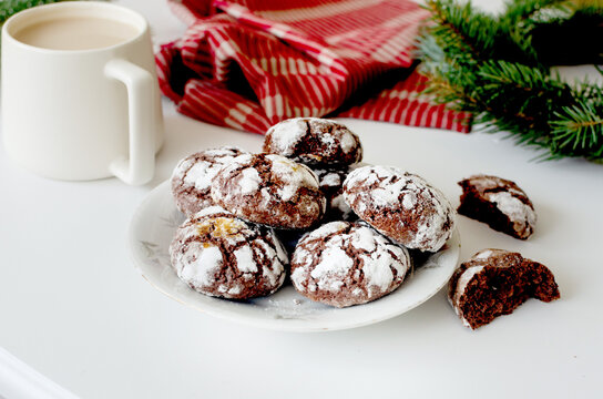 Homemade Cracked chocolate marble cookies for Christmas and cup tea with milk on table. Traditional American chocolate cookies for Christmas