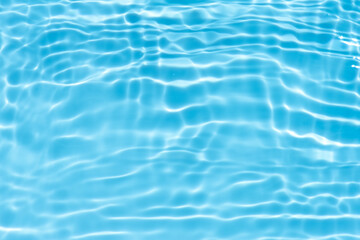 Blue water with ripples on the surface. Defocus blurred transparent blue colored clear calm water surface texture with splashes and bubbles. Water waves with shining pattern texture background.