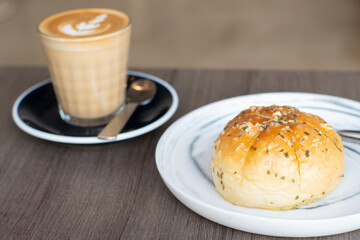 Bread filled with cream cheese and latte art on wooden table. Viral and popular bread. Korean cream cheese garlic bread.