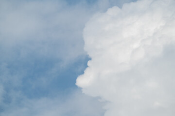 Fototapeta premium Dramatic cloudscape with fluffy cumulus clouds against a vibrant blue sky. This versatile image evokes feelings of freedom, peace, and possibility. 